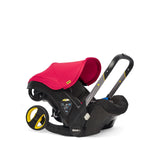 Flame red Doona car seat from the side.