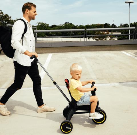 young toddler learning to ride a trike