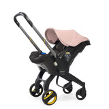 Pink doona stroller with extended handle.