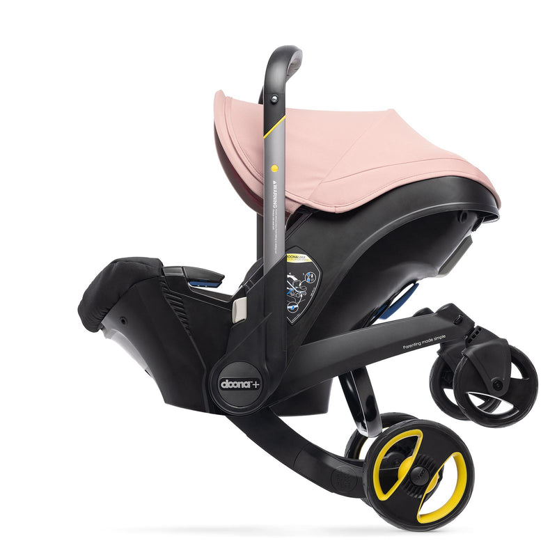 PInk Doona stroller being folded into car seat